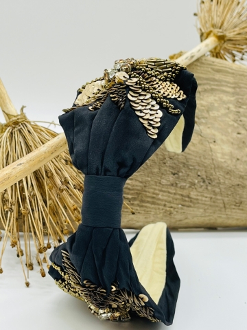 Elegante Haarspange mit schwarzem Stoff überzogen und mit goldenen Elementen verziert.