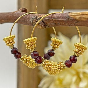 Goldene Ohrringe aus Edelstahl. Anhänger aus goldüberzogenen Charms, Hämatit- und Granat-Steinen "Grelia"